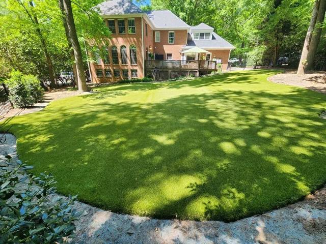 Elite Turfs synthetic lawn behind a brick home